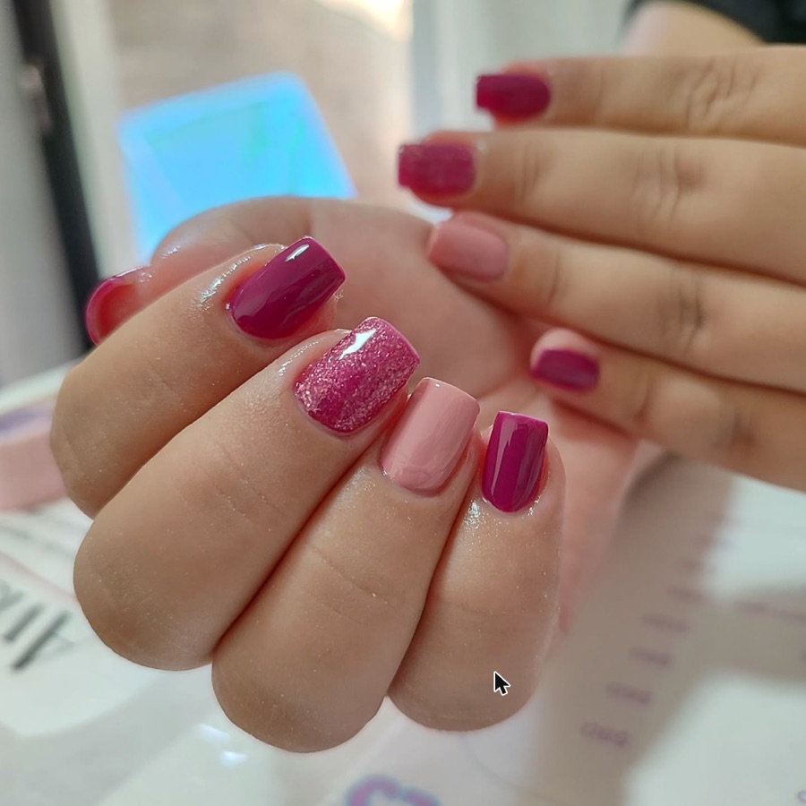 Unhas em tons de rosa e vinho com detalhe em glitter