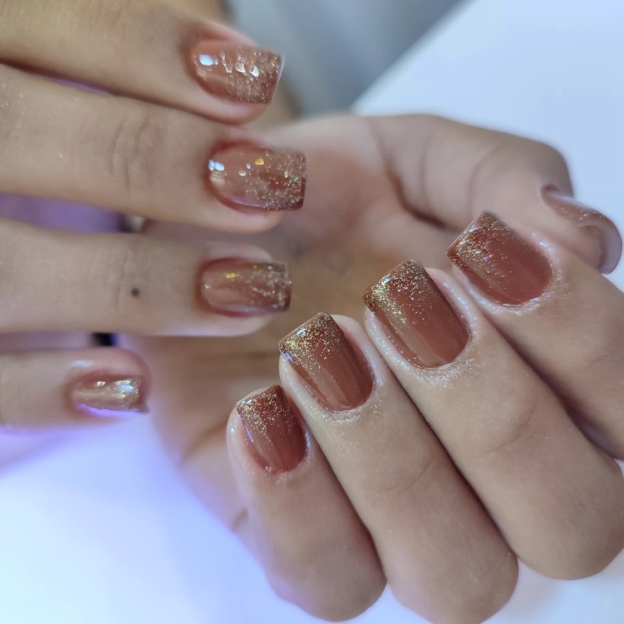 Unhas terracota com degradê de glitter dourado